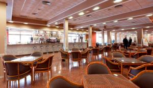 Un restaurante con mesas y sillas y un bar. en Hotel Cabana, en Benidorm