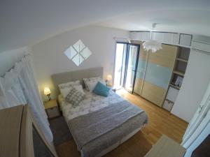 a small bedroom with a bed and a large window at Apartment and room Sveti Jakov in Dubrovnik