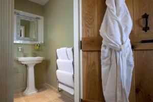 a bathroom with a white shower curtain and a sink at The Three Crowns in Chagford