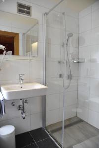 a bathroom with a glass shower and a sink at Hotel-Landgasthof Katschtalerhof in Rennweg