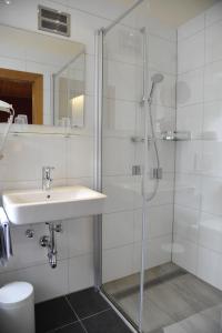 a bathroom with a shower, sink, and toilet at Hotel-Landgasthof Katschtalerhof in Rennweg