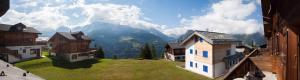 a view of a mountain from between two houses at Chalet Skilift in Rosswald