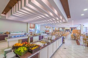 a cafeteria with a buffet line with fruits and vegetables at Kipriotis Hippocrates Hotel in Kos