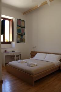 1 dormitorio con 1 cama con 2 toallas en I'MC IoAMoCagliari, en Cagliari