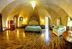 a bedroom with a bed and a couch and a table at Hotel Porto Pirgos in Parghelia