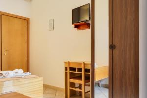 Cette chambre comprend un lit et une télévision murale. dans l'établissement Hotel Smile, à Rimini