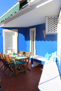 阿爾布費拉的住宿－Casa Mar Azul，一间拥有蓝色墙壁和桌椅的用餐室