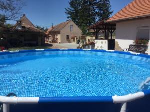 a large blue swimming pool in front of a house at Jarmila Vendégház in Balatonberény