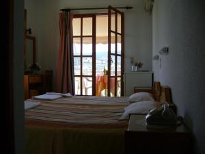 Un dormitorio con una cama grande y una ventana en Liberty II, en Agia Marina Aegina