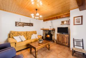 sala de estar con sofá y chimenea en Casa La Carpintera en Royuela