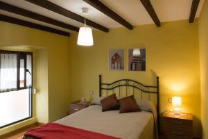 ヌエバ・デ・リャネスにあるCasa Nogalのベッドルーム1室(黄色い壁のベッド1台付)