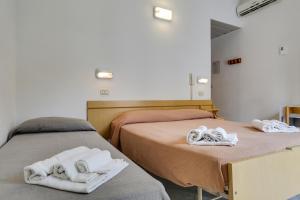 2 letti con asciugamani in una stanza di Hotel Smile a Rimini