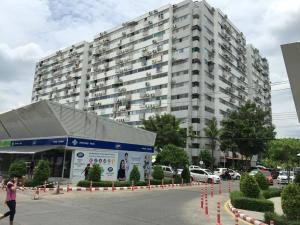 a large building in front of a parking lot at Condo Muang Thong in Nonthaburi