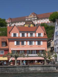 a building on the side of a river with buildings at Hotel Strand-Cafe Meersburg in Meersburg