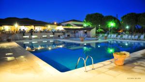 a swimming pool at night with people walking around at ULVF Les Residences du Colombier in Fréjus