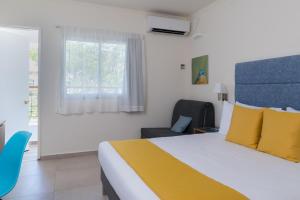 una camera con un letto e una sedia e una finestra di Americana Eilat Hotel a Eilat
