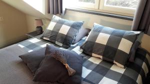um quarto com uma cama com almofadas em Hoeve Schevey em Mechelen