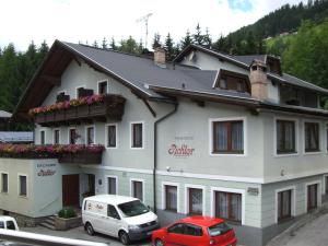 a white building with cars parked in front of it at Pension Pichler in Sillian