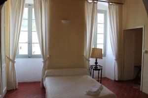 a bedroom with a bed and two windows at A Spelunca in Speloncato