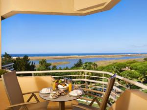 a table on a balcony with a view of the ocean at Hotel Quinta do Lago in Quinta do Lago
