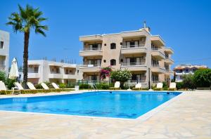 a hotel with a swimming pool in front of a building at Niko Elen in Stalís