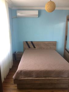 um quarto com uma cama e uma parede azul em Apartment On Khinikadze 4 em Batumi