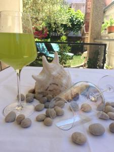 szklankę wina obok muszli i szklankę kamieni w obiekcie Apartment T&J w mieście Zadar