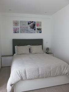 ナザレにあるSerenabeachの白いベッドルーム(白いシーツを使用した大型ベッド1台付)