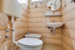 a bathroom with a toilet and a sink and a mirror at Hotel Smile in Rimini