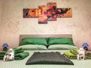 ナポリにあるCasa "G&G Pignasecca"のベッドルーム1室(壁に絵画が飾られた緑のベッド1台付)