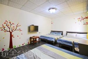 Zimmer mit 2 Betten und einem Baum an der Wand in der Unterkunft Hai Yin in Green Island