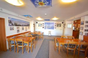 a restaurant with wooden tables and chairs and pictures on the walls at Apartmány Biela Púť 17 - 18 in Demanovska Dolina