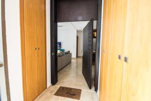 einen Flur, der zu einem Wohnzimmer mit einem Spiegel führt in der Unterkunft Marina Rabat Suites & Apartments in Salé