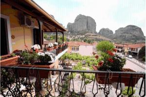 a balcony with potted plants and mountains in the background at Guesthouse Patavali in Kalabaka