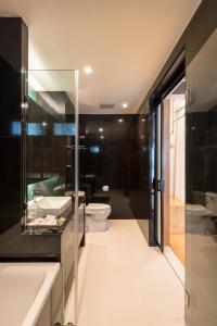 a bathroom with a toilet and a sink and a shower at Asana Hotel & Residence in Pattaya Central +58 photos