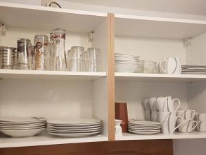 un meuble rempli d'assiettes, de tasses et de plats dans l'établissement Ferienwohnung Tannenweg / Poseritz, à Poseritz