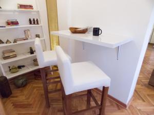 two white stools sitting at a table in a room at Apartment Niš Center in Niš