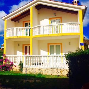 a yellow and white house with a balcony at Apartment Emanuela in Rovinjsko Selo
