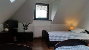 ein kleines Schlafzimmer mit einem Bett und einem Fenster in der Unterkunft Willa Ostoja in Rabka-Zdrój