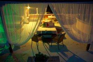 tavolo e sedie in una stanza con tende di Galini Hotel ad Agia Marina