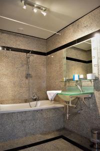 a bathroom with a tub and a sink and a mirror at Hotel Maurice in Nieuwvliet