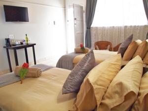 a hotel room with two beds with pillows on them at Travel Lodge Sabie in Sabie