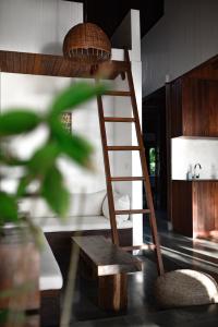 a wooden bunk bed with a ladder and a bench at Asmara Villa in Nusa Lembongan