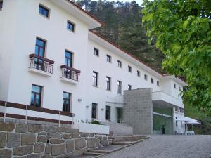 um grande edifício branco com uma parede de pedra em INATEL Manteigas em Manteigas