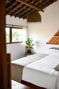 a bedroom with a white bed and a potted plant at Asmara Villa in Nusa Lembongan +42 photos