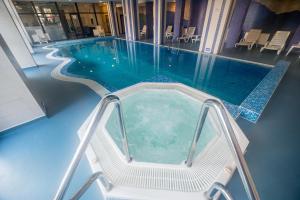 - une piscine dans un hôtel avec un visiorvisor vide dans l'établissement Rhodopi Home Hotel Chepelare - Half board, à Chepelare