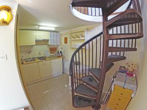 Eine Wendeltreppe führt zu einer Küche mit einer Küche. in der Unterkunft Appartamento Mestrino in Prasco