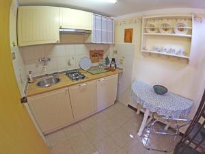 eine kleine Küche mit einem Waschbecken und einem Tisch in der Unterkunft Appartamento Mestrino in Prasco