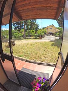 Blick auf den Garten von einer Glastür mit Blumen in der Unterkunft Appartamento Mestrino in Prasco