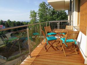 a balcony with a wooden table and chairs on it at Apartament Sandra in Karpacz
